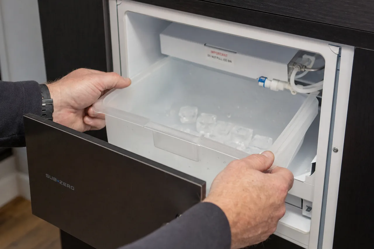 Technician servicing a built-in ice maker up close